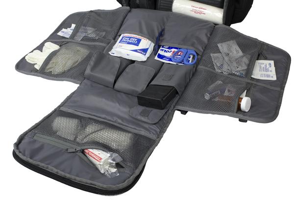 An open Elite Survival Systems Tenacity-72 Three Day Support/Specialization Backpack displaying various medical supplies such as bandages, gauze, and medicine packets.
