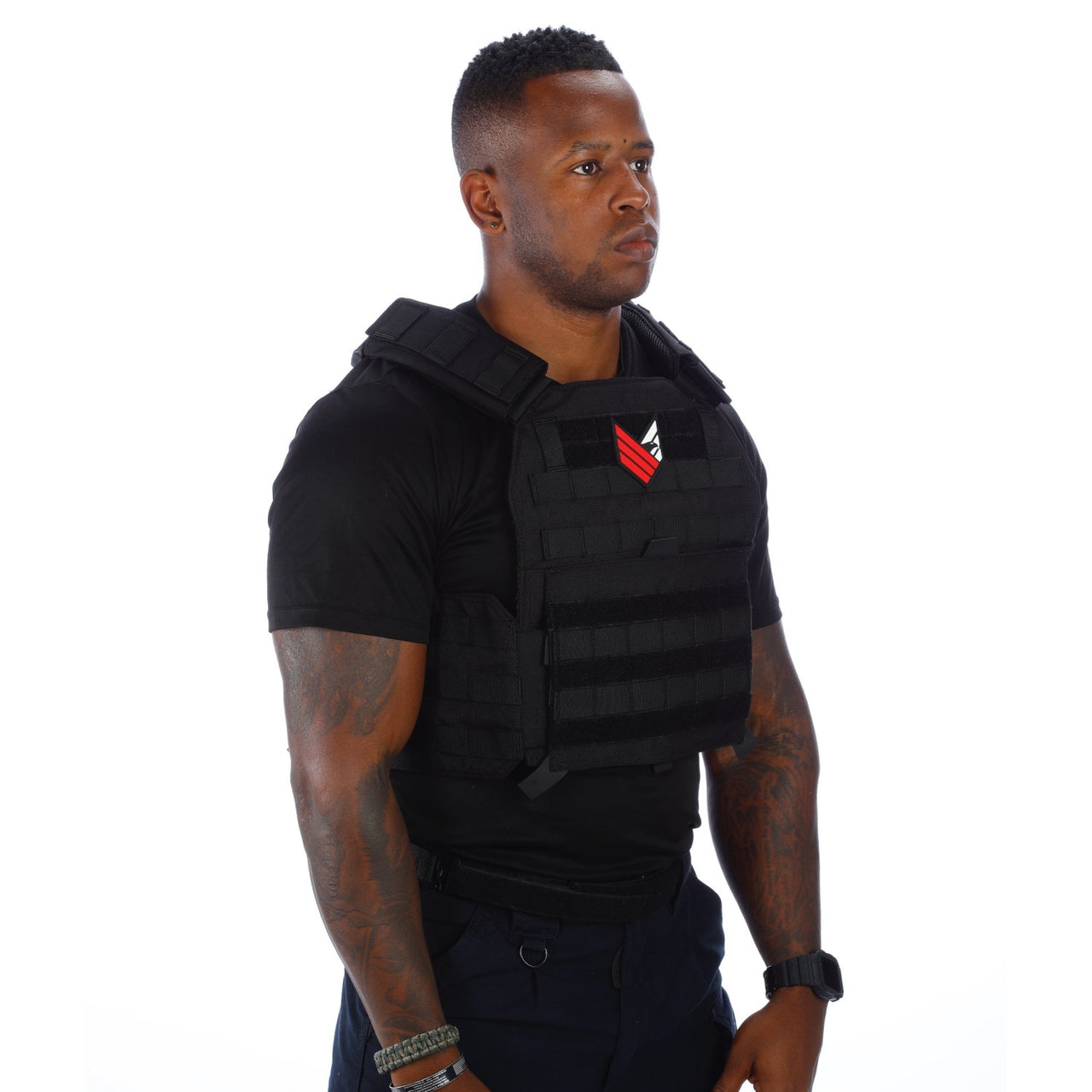 A black man wearing a Body Armor Direct Advanced Body Armor Plate Carrier with Cummerbund on a white background.