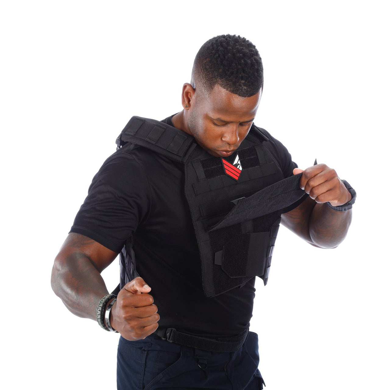 A man in a black vest is holding his Body Armor Direct Advanced Body Armor Plate Carrier with Cummerbund.