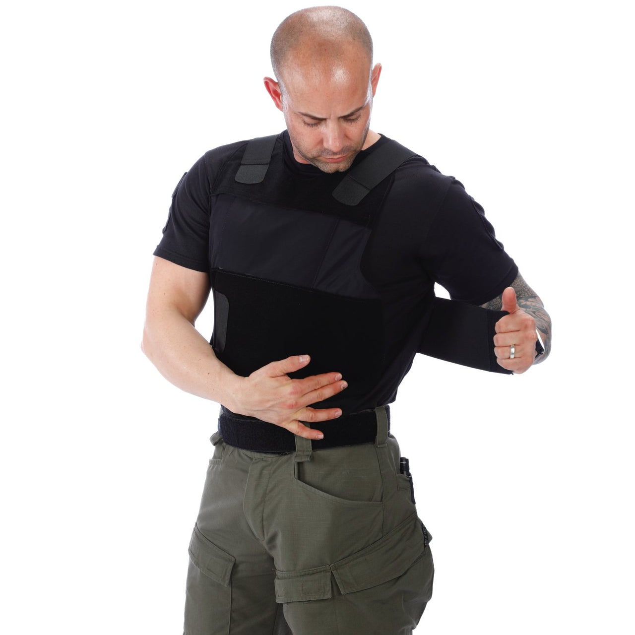 A man in a green shirt is putting his hand on his Body Armor Direct All American Concealable Enhanced Multi-Threat Vest.