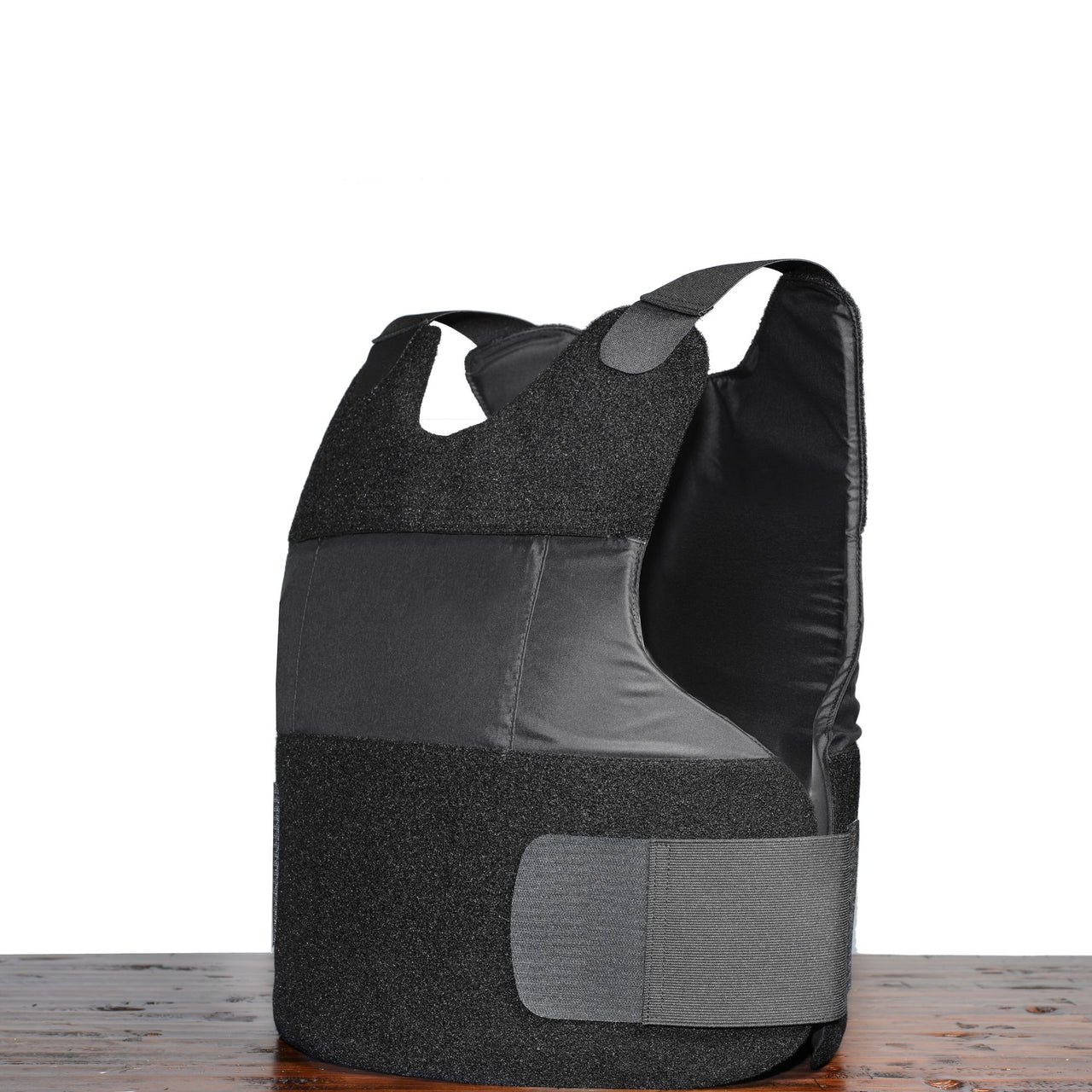 A Body Armor Direct Freedom Concealable Carrier vest in grey and black on top of a wooden table.