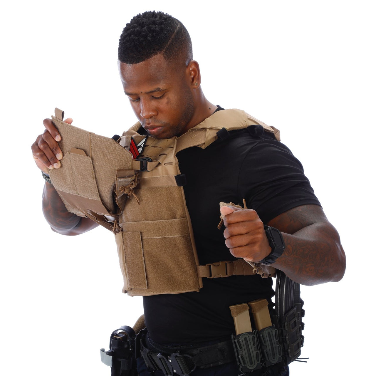 A man wearing a Body Armor Direct Expert Plate Carrier looking at his phone.