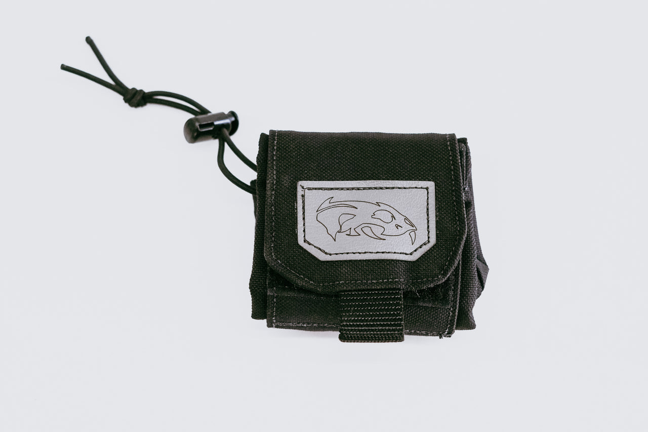 Small black Predator Armor Dump Pouch with a velcro flap and a native American-style embroidered emblem, featuring a white dolphin design, set against a plain white background.