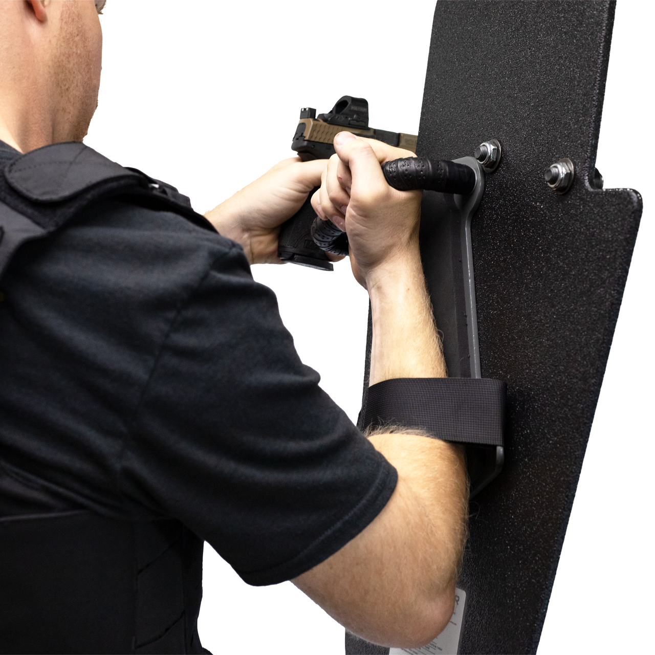 left handed officer holding a 15" x 25" Caliber Armor Rifle rated Level III+ RF2 Ballistic Shield with pivoting handle mounted for right handed use aiming through a pistol with sight 
