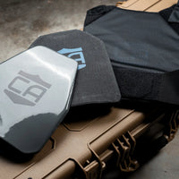 Thumbnail for A Caliber Armor tactical vest with a MOLLE compatible Triple AK Kangaroo Mag Pouch and armor plates sits atop a tan hard case, displaying visible Caliber Armor logos and textured surfaces.