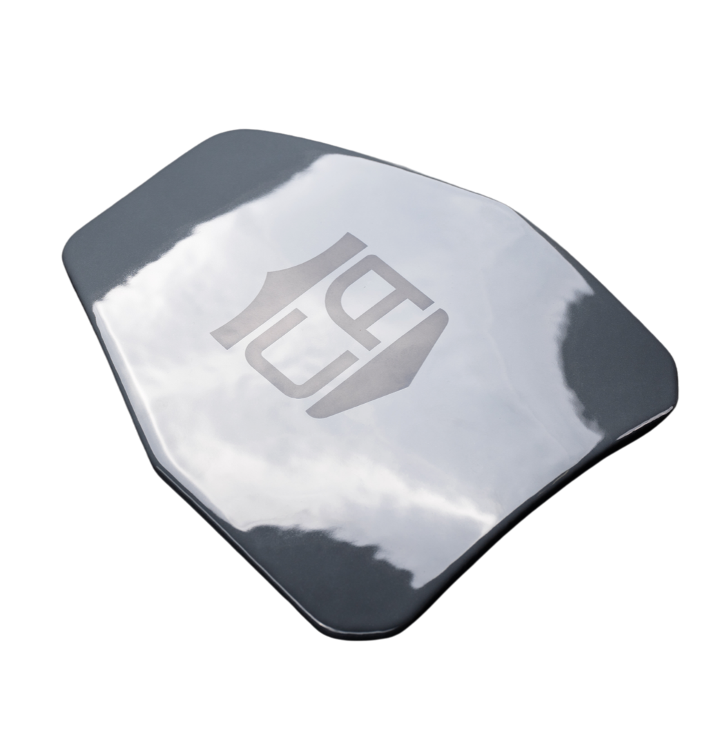 The Caliber Armor AV2 Multi-Curve RF2 Body Armor features a shiny, irregularly shaped steel plate with an engraved logo that reflects the sky and clouds.