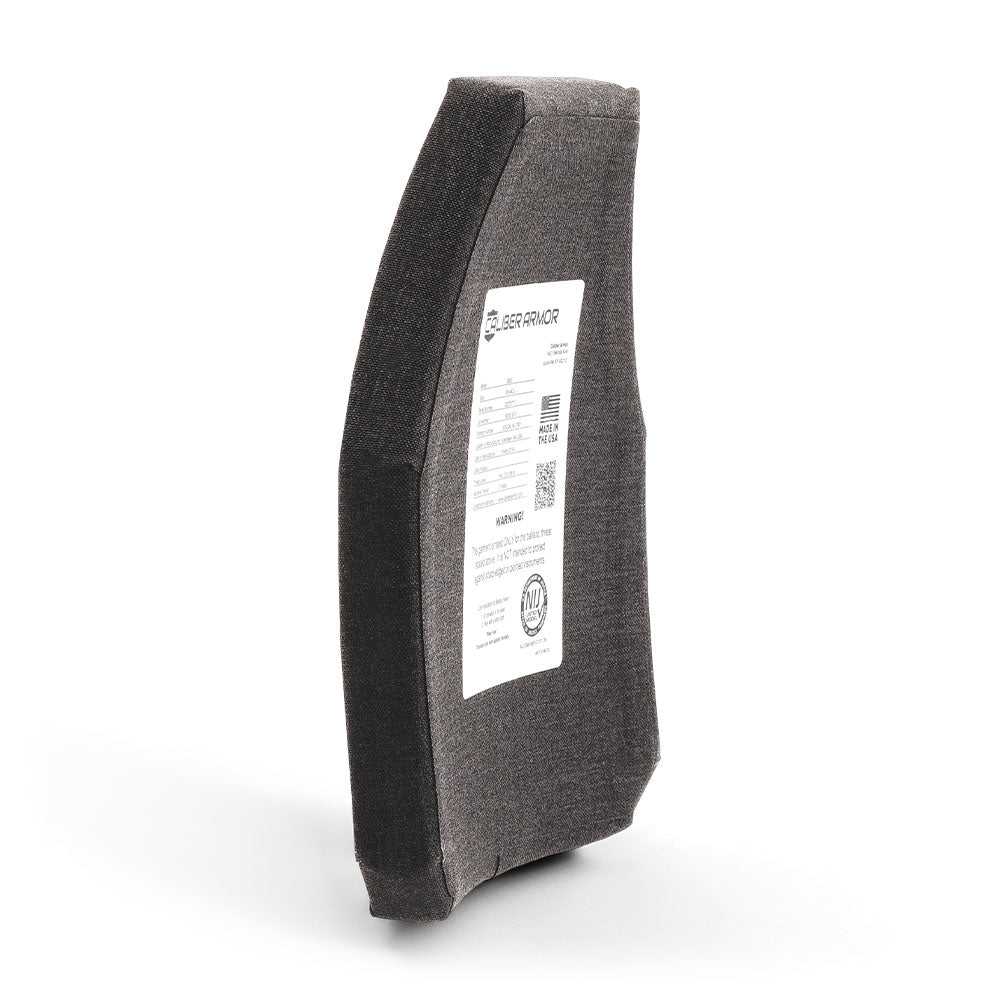 A black, rectangular Caliber Armor Level IV Multi-Curve ceramic body armor plate with a fabric cover and white label stands upright at an angle against a plain background.