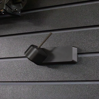 Thumbnail for Black plastic barrel mounted pistol hanger that has a carbon fiber rod, shown mounted to our Assault Wall tactical slat wall panel
