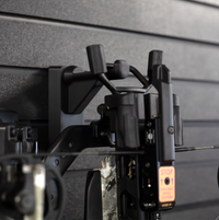 Thumbnail for Close up of black plastic hanger for crossbows shown mounted to a black tactical gear slat wall named Assault Wall