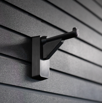 Thumbnail for black plastic hanger for compound bows and crossbows shown mounted to a black tactical gear slat wall named Assault Wall