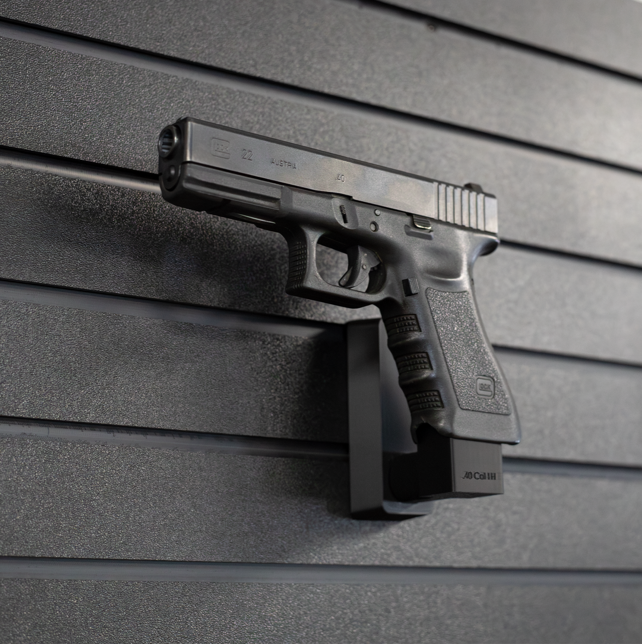Left facing black plastic magazine mounted 40 Cal pistol hanger installed on Assault Wall Tactical slat wall