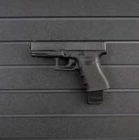 Thumbnail for Left facing black plastic magazine mounted 9mm pistol hanger installed on Assault Wall Tactical slat wall