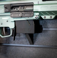 Thumbnail for Close-up of an AK-47 rifle mounted by its magazine well on an Assault wall caliber specific gun mount installed on a slat wall