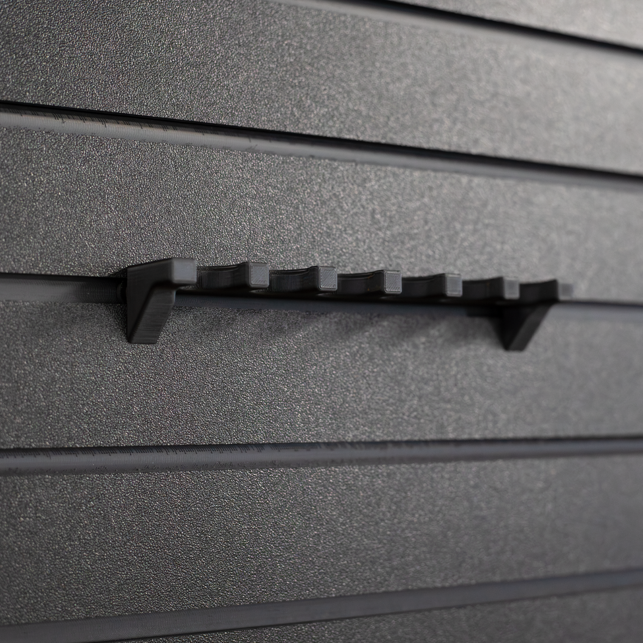 Close-up of a six shotgun shell hanger without shells loaded that has been mounted to an Assault Wall tactical slat wall panel