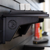 Thumbnail for Close up of black plastic shelf support that branded lwith a Double Tap logo also showing the shelf profile, both are mounted to our black slat wall blurred in the background