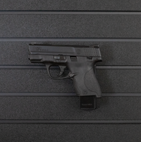 Thumbnail for Left facing black plastic magazine mounted 9mm single stack pistol hanger installed on Assault Wall Tactical slat wall