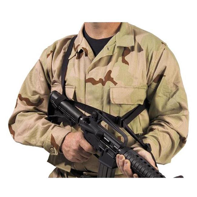 A person in camouflage military uniform holding an Elite Survival Systems Quick-Adapt Tactical Sling, cropped to show only from the neck down.