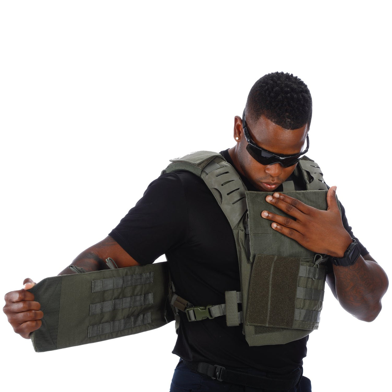 A man wearing sunglasses adjusts his Body Armor Direct Victory Plate Carrier Deluxe Edition, looking down at the fit.