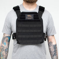 Thumbnail for A man with tattoos wearing a black Predator Armor Minuteman Plate Carrier.