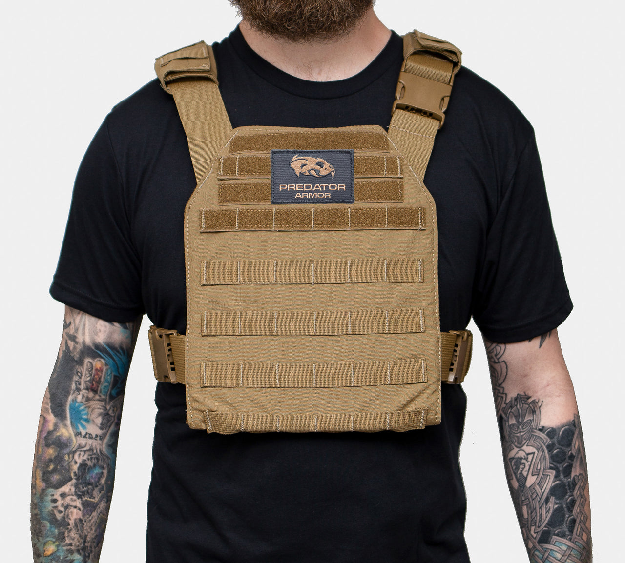 A man with a beard and tattoos wearing a Predator Armor Minuteman Plate Carrier.