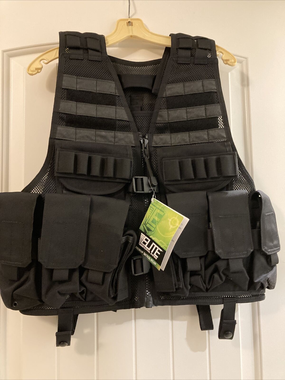 An Elite Survival Systems MVP Payload Tactical Vest hanging on a door.